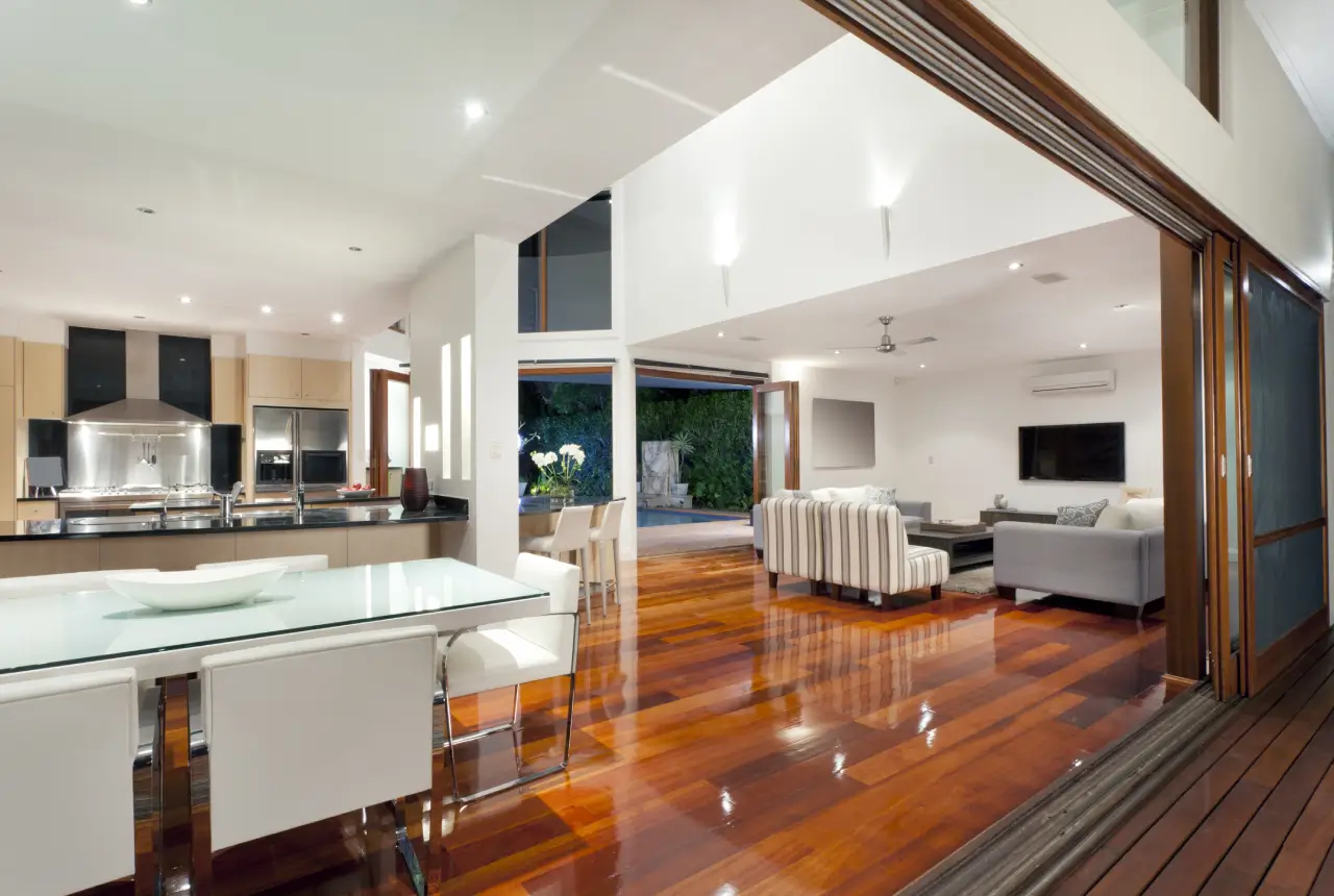 A large open living room with wood floors and white furniture.