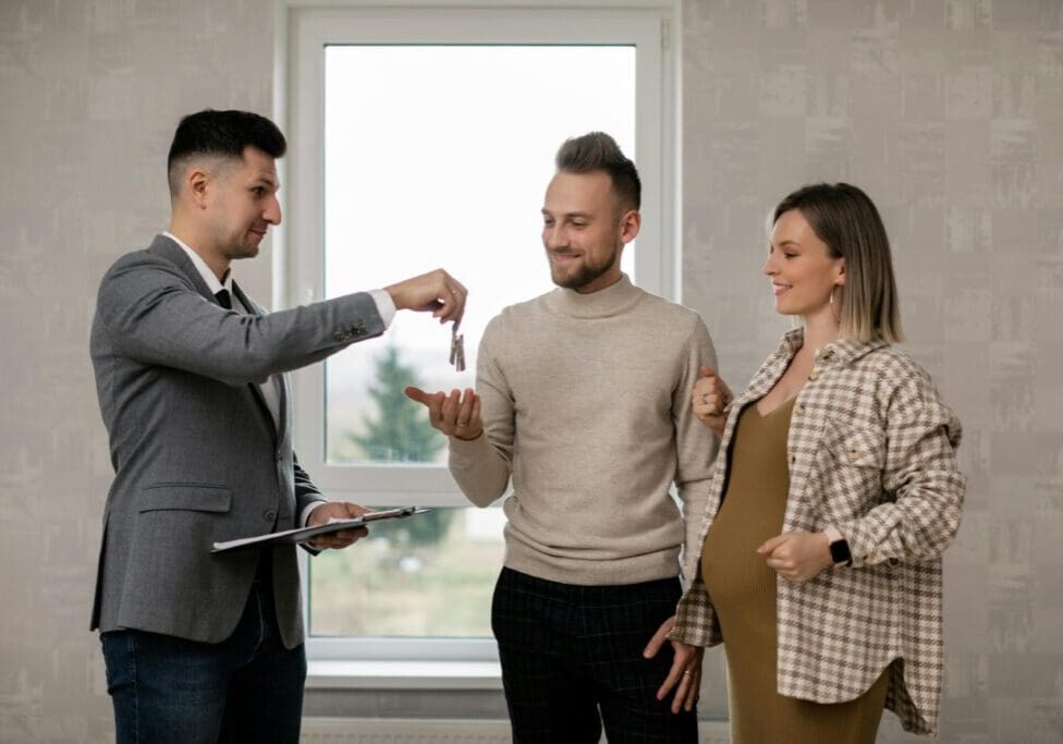 A man holding a key to his new apartment.
